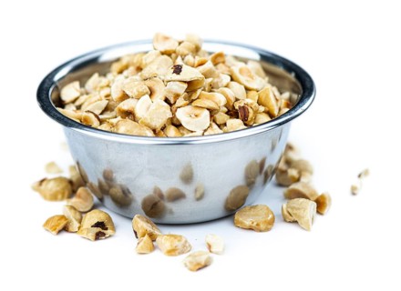 Freshly chopped Hazelnuts as detailed close up shot isolated on white background (selective focus)
