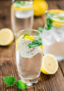 Homemade Lemonade on an wooden table (selective focus) as detailed close-up shot
