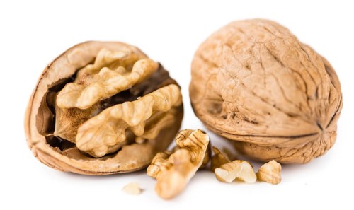 Portion of Walnuts (as close-up shot) isolated on white background
