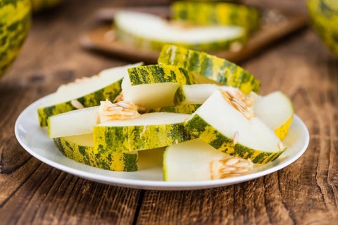 Futuro Melons on an old wooden table as detailed close-up shot (selective focus)