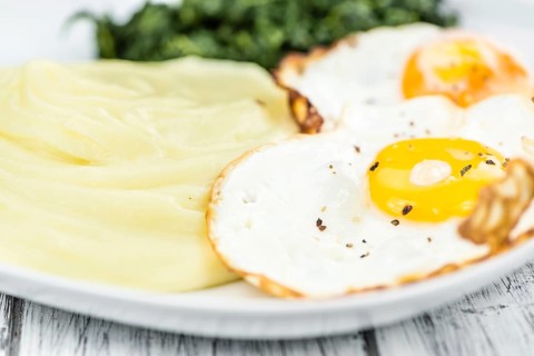 Some homemade Mash (selective focus) as detailed close-up shotwith fried eggs and spinach