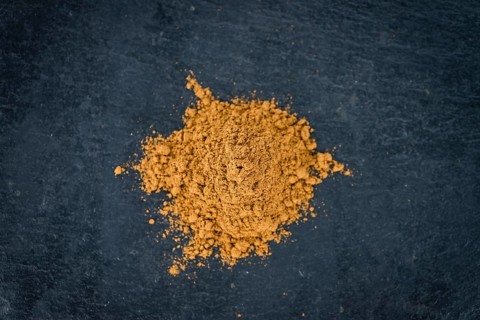 Portion of Cinnamon Powder on a rustic slate slab (selective focus, close-up shot)