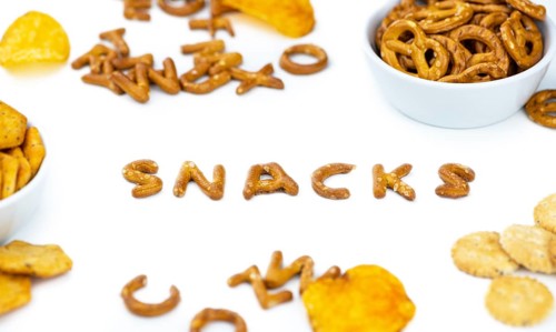 Portion of mixed Snacks isolated on white background (detailed close up shot, selective focus)