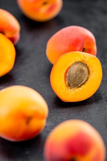 Portion of Apricots as detailed close up shot on a slate slab (selective focus)