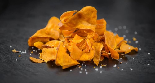 Some fresh Sweet Potato Chips on a vintage slate slab, selective focus, close-up shot