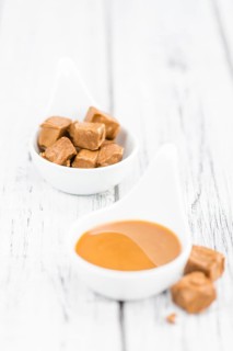 Caramel Sauce on a vintage background as detailed close-up shot (selective focus)