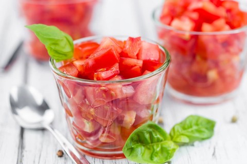 Tomatoes (diced) as high detailed close-up shot on a vintage wooden table (selective focus)