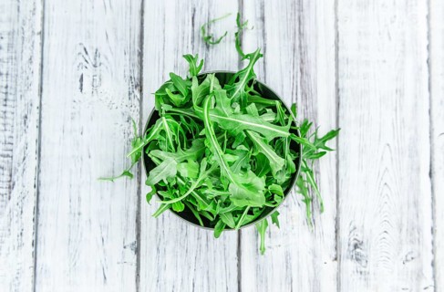 Fresh Arugula (selective focus) as detailed close-up shot on vintage background