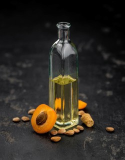 Portion of Apricot Oil with some fresh fruits as detailed close up shot (selective focus)