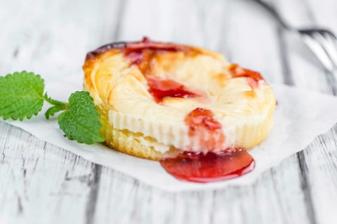 Cheesecake with berry Sacue on a vintage background as detailed close-up shot (selective focus)