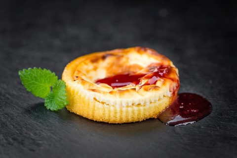 Cheesecake with Sauce on a vintage slate slab (close-up shot, selective focus)