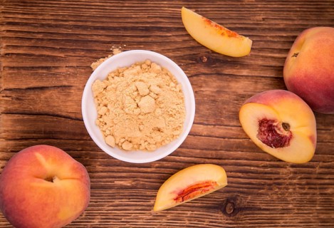 Ground Peaches as high detailed close-up shot on a vintage wooden table, selective focus