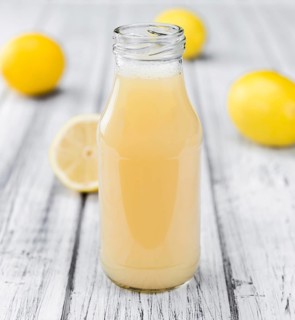 Homemade Lemon Juice on an wooden table (selective focus) as detailed close-up shot