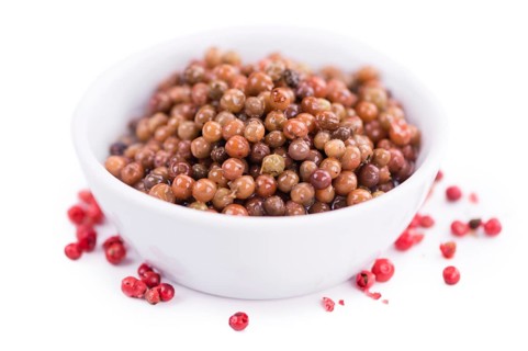 Preserved Pink Peppercorns isolated on white background, selective focus, close-up shot
