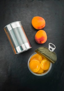Portion of Canned Apricots as detailed close up shot on a slate slab (selective focus)