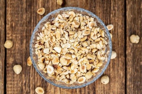Freshly chopped Hazelnuts as detailed close up shot (selective focus)