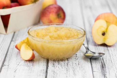 Portion of fresh made Applesauce (selective focus) on a wooden table