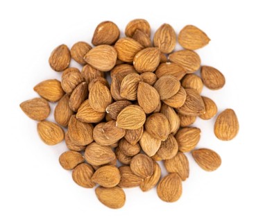 Portion of Apricot Kernels isolated on white background as detailed close up shot (selective focus)