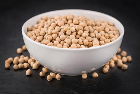 Some dried Chickpeas on a slate slab as detailed close-up shot, selective focus