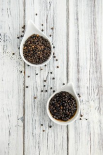 Black Peppercorns preserved on wooden background, selective focus, close-up shot