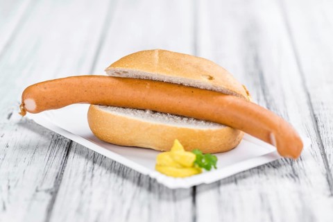 Sausages (Frankfurter) on rustic wooden background (close-up shot)