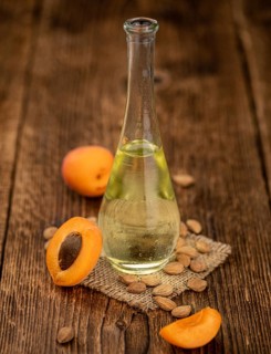 Portion of Apricot Oil with some fresh fruits as detailed close up shot (selective focus)