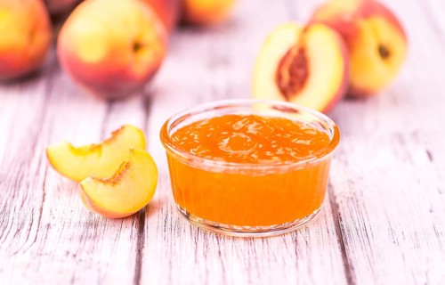 Homemade Peach Jam on an wooden table as detailed close-up shot, selective focus