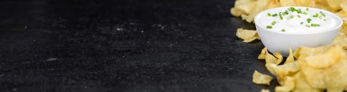 Some Potato Chips with Sour Cream taste on a slate slab (close-up shot, selective focus)