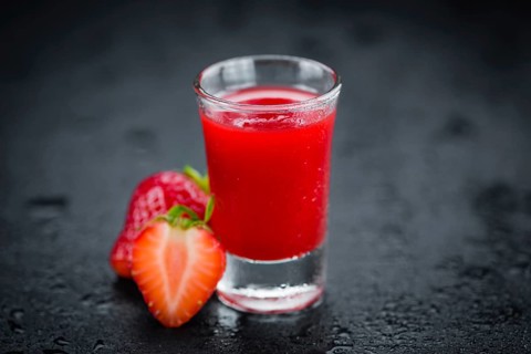 Strawberry liqueur on a vintage slate slab as detailed close-up shot, selective focus