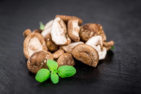 Portion of Shiitake mushrooms as detailed close up shot on a slate slab, selective focus