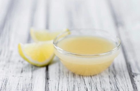 Fresh made Juice (lemon) on an old and rustic wooden table (selective focus, close-up shot)