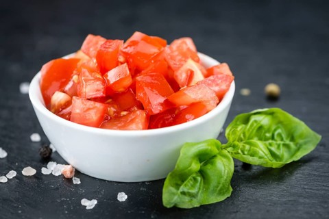 Some fresh Diced Tomatoes on a vintage slate slab (selective focus, close-up shot)
