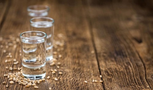 Vintage wooden table with Wheat Liqueur (selective focus, close-up shot)