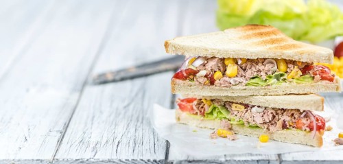 Homemade Tuna Sandwich (selective focus, close-up shot) on vintage wooden background