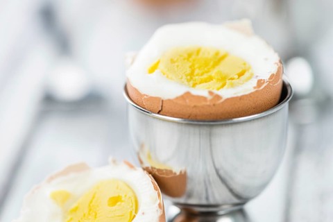 Some boiled Eggs (close-up shot, selective focus) on an old wooden table