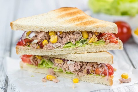 Wooden table with a fresh made Tuna Sandwich (selective focus, close-up shot)