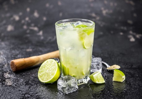 Fresh made Caipirinha with ingredients in the background