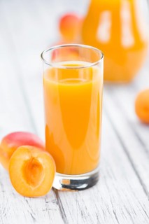 Fresh made Apricot Juice on a vintage background (close-up shot)