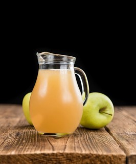 Apple Juice on a vintage background as detailed close-up shot (selective focus)
