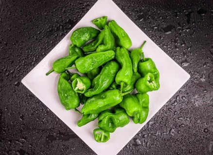 Portion of Raw Pimientos on a rustic slate slab, selective focus, close-up shot