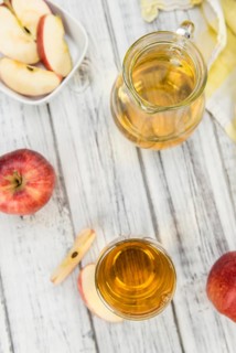 Apple Cider as high detailed close-up shot on a vintage wooden table (selective focus)