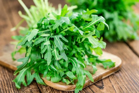 Fresh Arugula on an old wooden table as detailed close-up shot