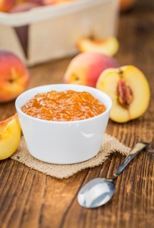 Homemade Peach Jam on an wooden table as detailed close-up shot, selective focus