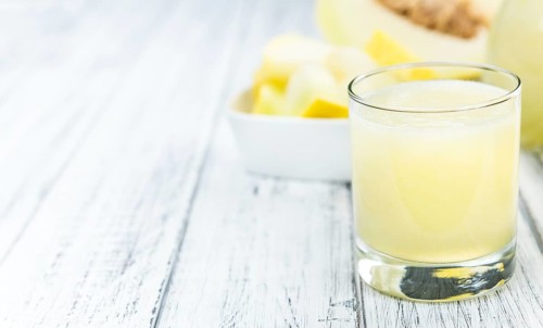 Honeydew Melon smoothie (close-up shot, selective focus) on a wooden table