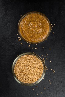 Some German Cuisine (sweet Mustard) on a slate slab (close-up shot, selective focus)