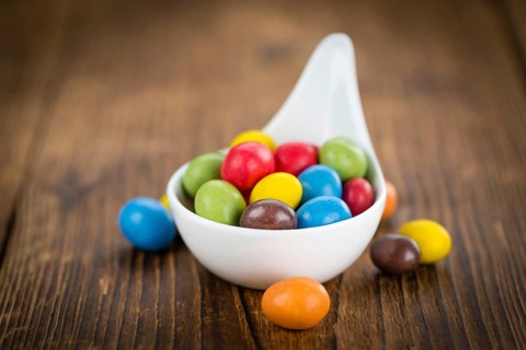 Fresh made Cocolate coated Peanuts on a vintage background (close-up shot)