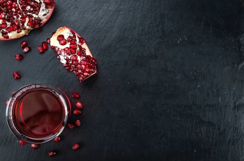 Fresh made Pomegranate juice on a vintage background (close-up shot)