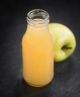 Portion of Juice (apple) on a rustic slate slab (selective focus, close-up shot)
