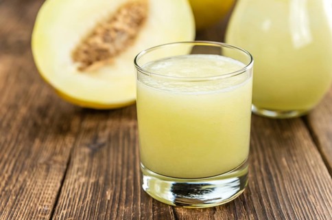 Honeydew Melon smoothie (close-up shot, selective focus) on a wooden table
