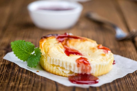 Cheesecake with Sauce on an old wooden table as detailed close-up shot (selective focus)